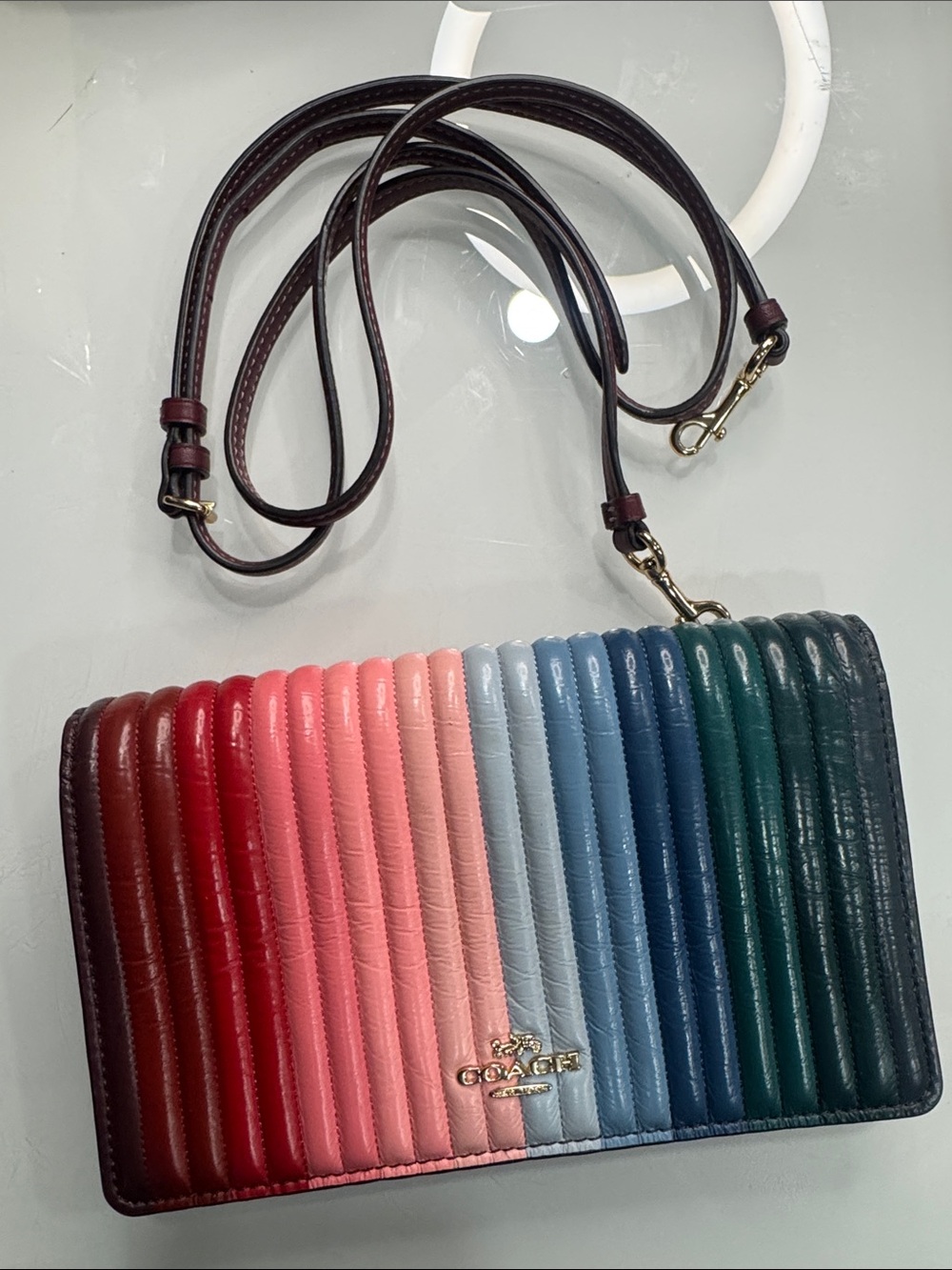 Coach Anna Foldover crossbody clutch featuring a rainbow quilting
